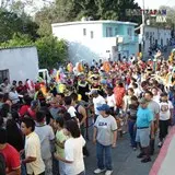 Calle llena de personas que les gusta el carnaval