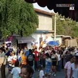 Multitud de gente en la comparsa brincando al compas de la banda de viento