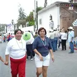 Amigas sonriendo mientras caminan para encontrar el desfile