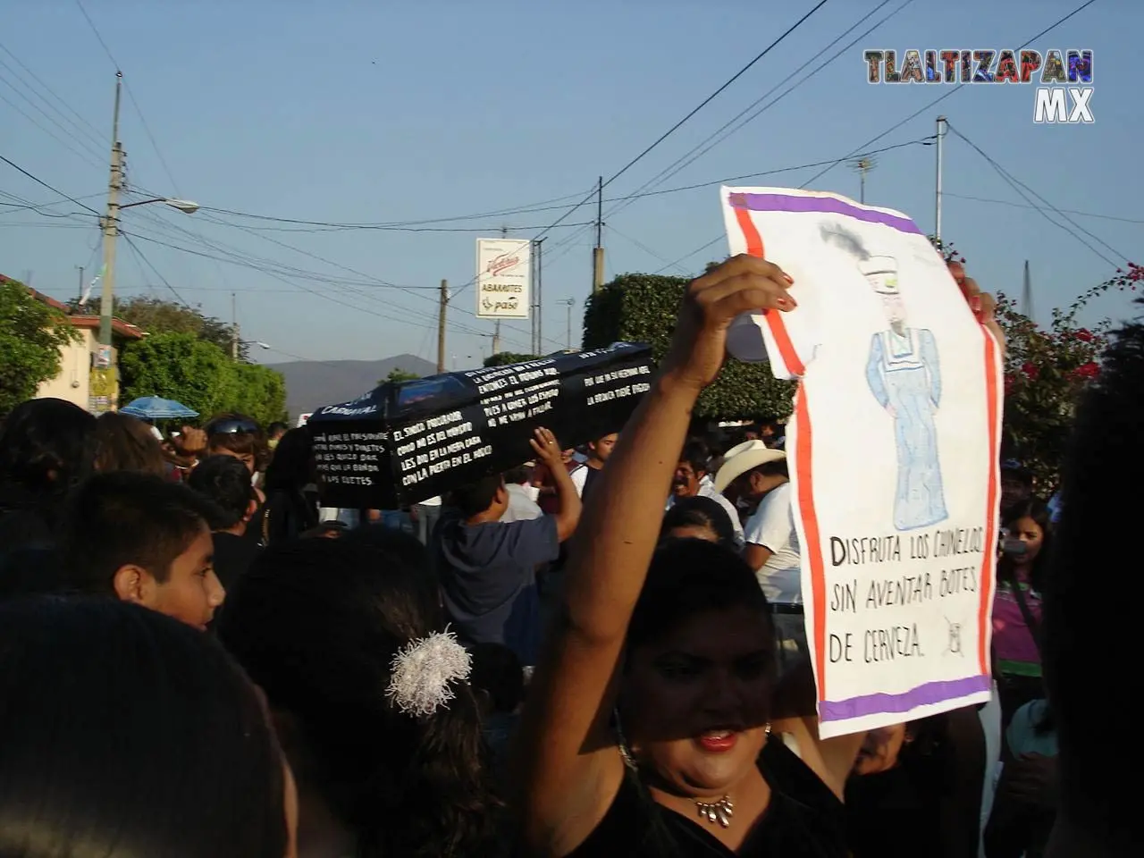 Las personas  llevan pancartas ,disfrutando del comienzo de carnaval 2006