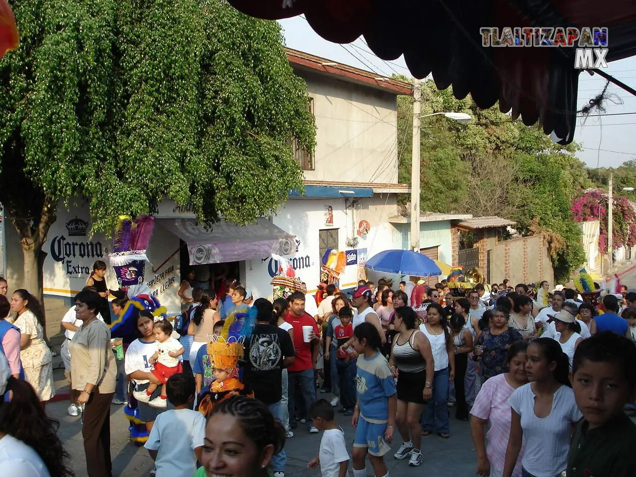 Multitud de gente en la comparsa brincando al compas de la banda de viento